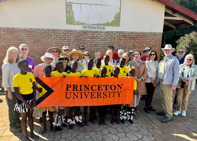 Group of school children and Princeton travelers with Princeton banner