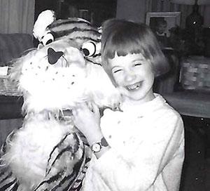 A young Beth Gilson with a stuffed Tiger