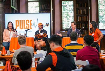 4 alumni sit on a panel talking to PULSE participants