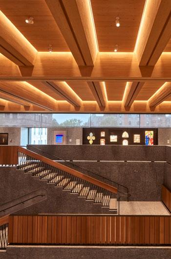 A large staircase leads to a display of various artworks in a gallery