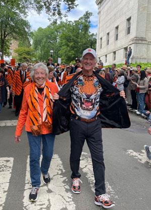 Susien and John Diekman walking in a parade wearing orange and black