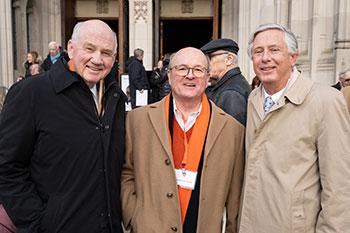 Three men in front of chapel