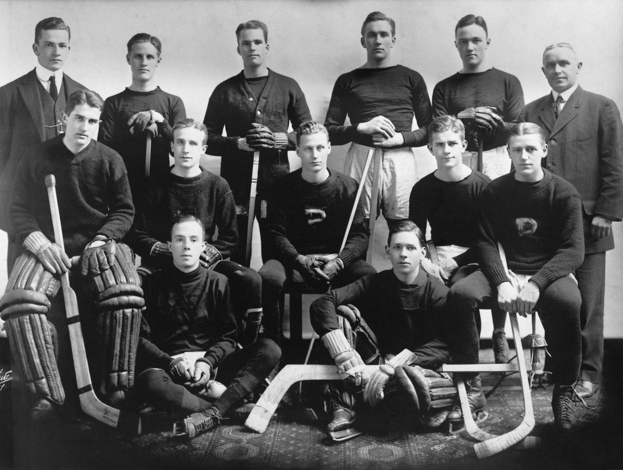 Black and white team photo of the Princeton ice hockey team, with Hobey Baker seated in the middle