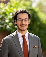 Portrait of Jamil Fayad, wearing gray suit, orange tie and eyeglasses.